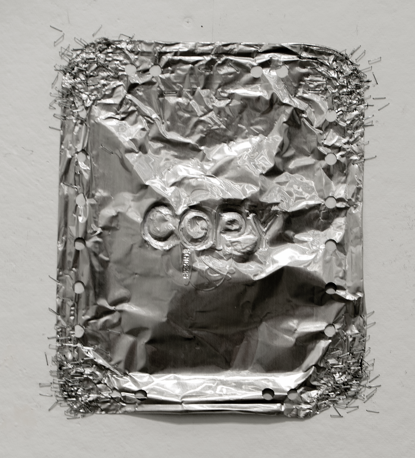 An aluminum cover for a to-go pan that has the word 'copy' etched into it
