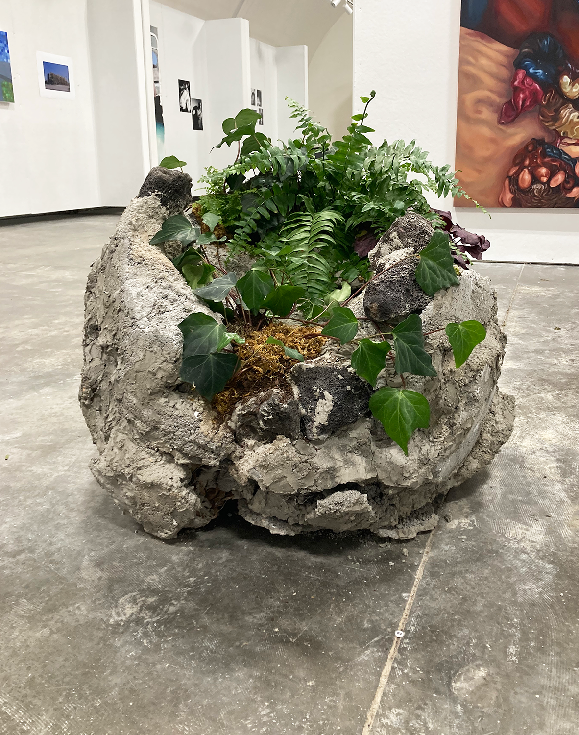 Sculpture of a rock made of concrete and plaster as well as organic materials. 