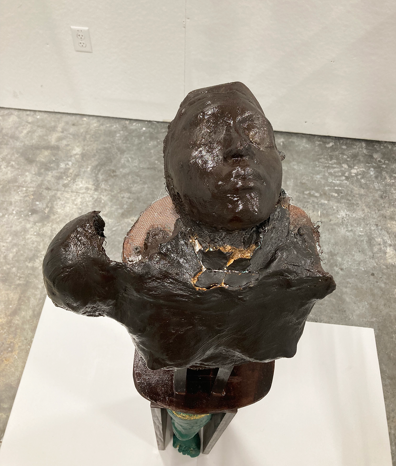 Sculpture of a bust and leg as seen from above
