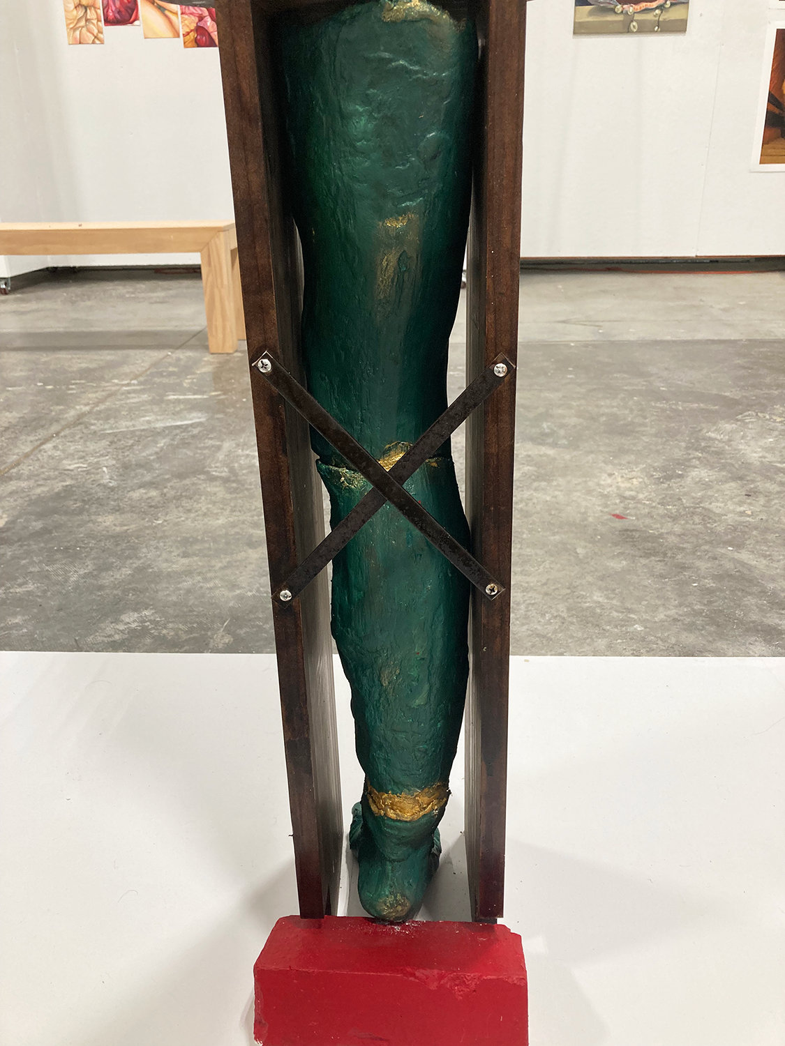 Sculpture of a leg painted green seen from the back
