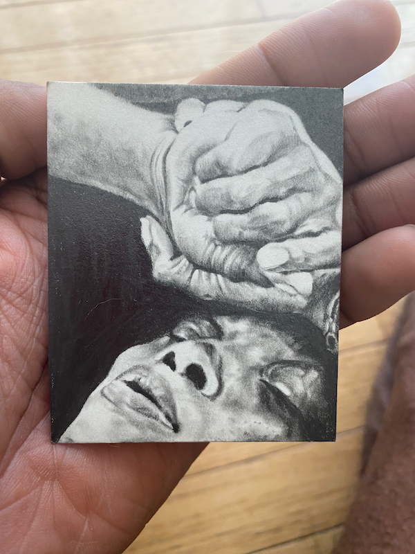 Image of hand holding a sketch of a woman.