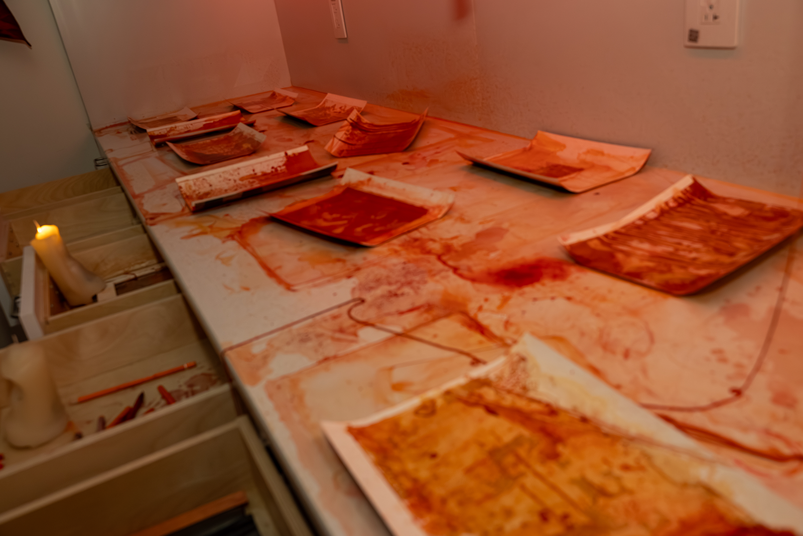 Close up of papers on a counter with red dye all over