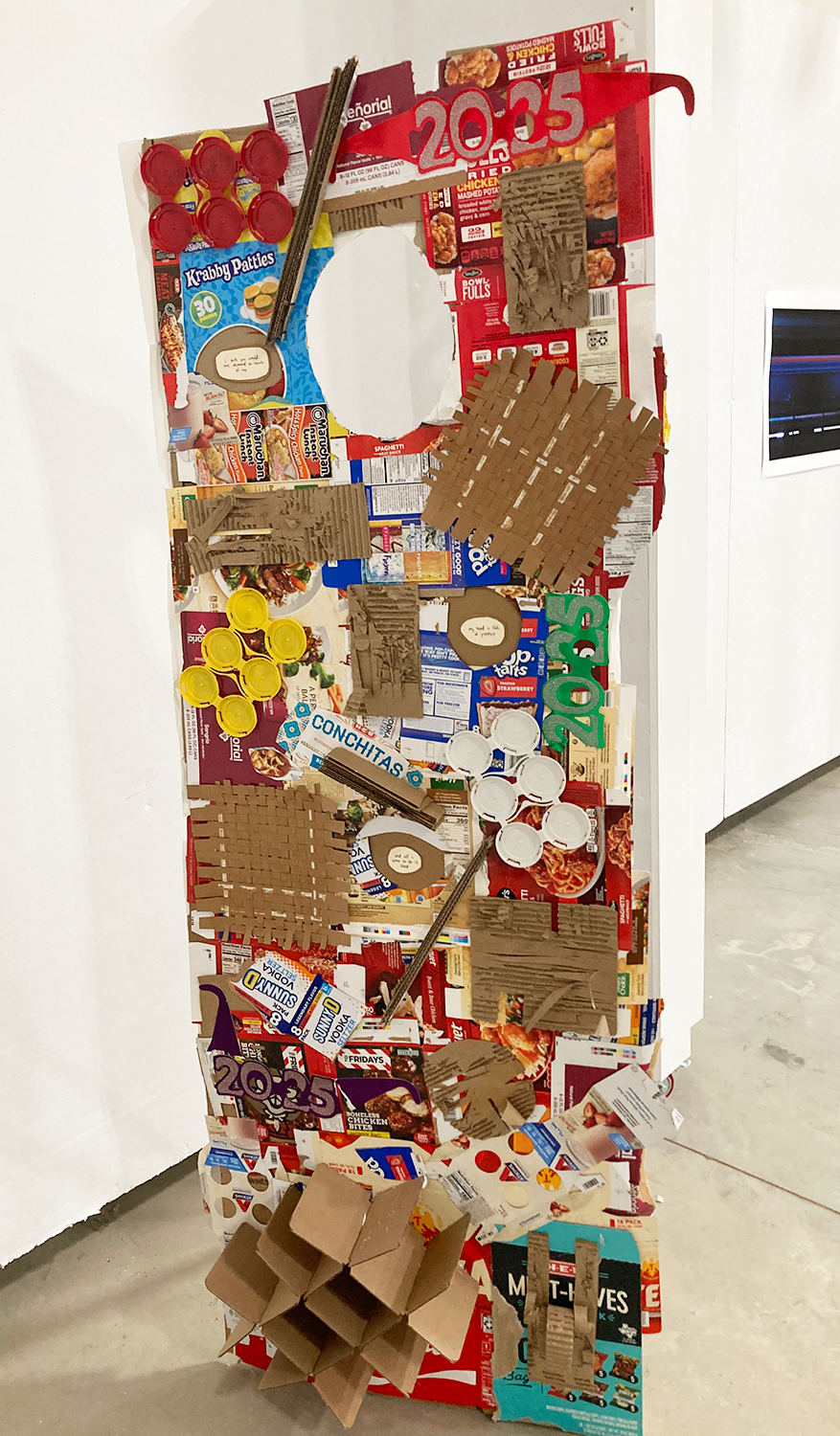 A piece made of packaging with a space cut out for a person's face to fit (or show) through