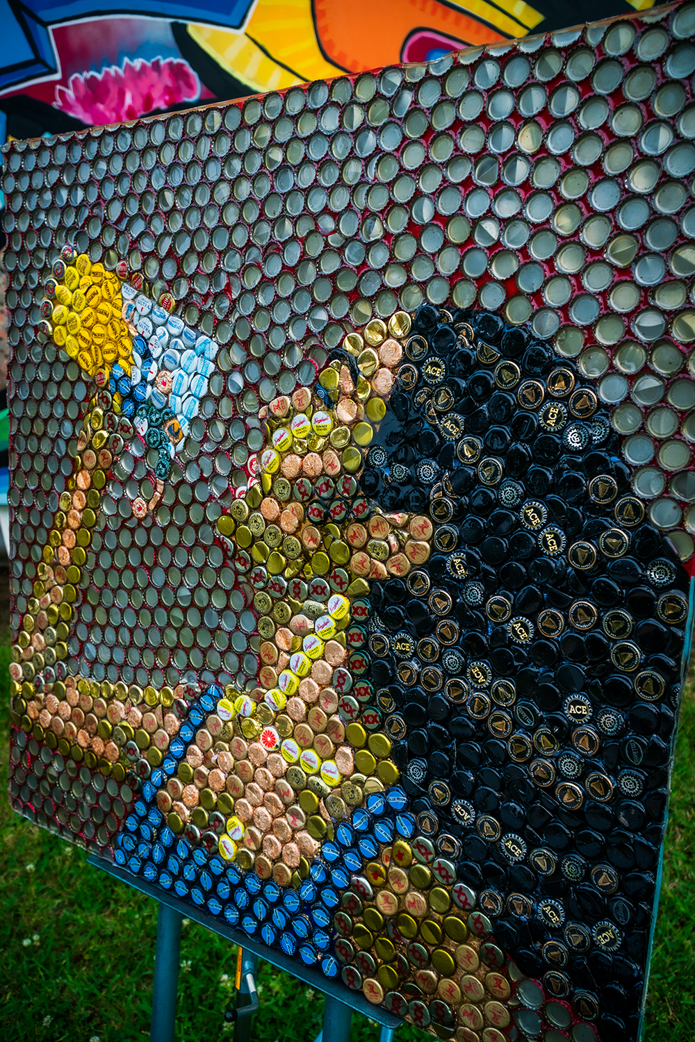 Bottle caps creating an image of a woman drinking a glass of liquid, with resin 